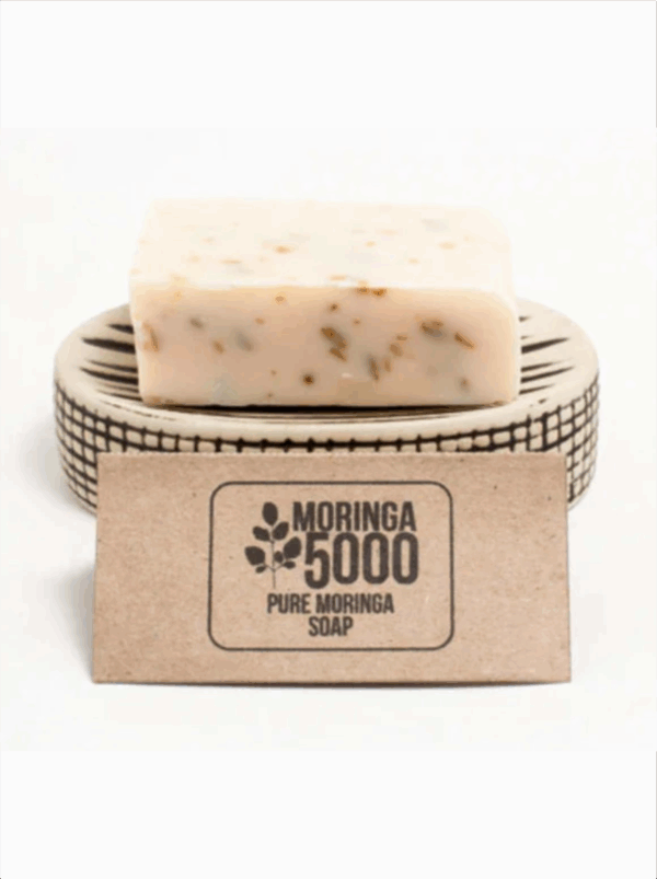 A bar of Moringa 5000 Pure Moringa Soap on a small soap dish.