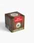 A small, rustic-looking box of Rexi's Herbal Balm, with a wood grain design and a red band. The box shows a picture of the product inside and the words "Rexi's Herbal Balm."
